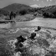 Bratranci a přátelé Rafaela Nahuela plavou v řece Ñirihuau. Nahuel (22) byl zabit během útoku vládních sil na domorodé aktivisty v listopadu 2017. Bariloche, Rio Negro, Argentina, 29. ledna 2019.