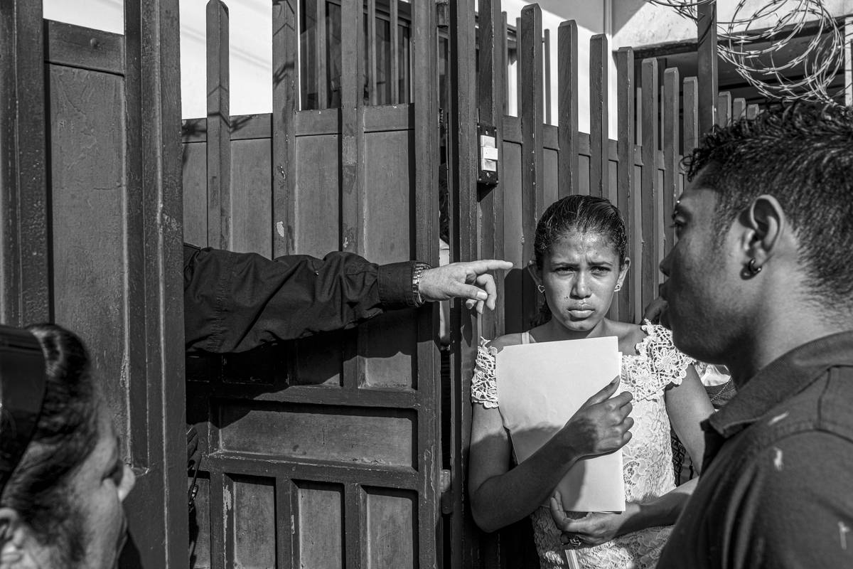 Na snímku čekají žadatelé o azyl před branami Mexické komise pro pomoc uprchlíkům (COMAR) na slyšení, v němž žádají o udělí humanitárních víz k pobytu v Mexiku či k cestě přes celou zemi do Spojených států. COMAR byl obviněn z korupce a zdržování schvalování humanitárních víz. Tapachula, Mexiko, 18. června 2019.