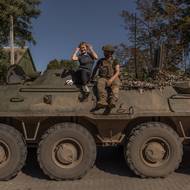 Žena pózuje na obrněném transportéru vedle ukrajinského vojáka v Kosťantynivce v Doněcké oblasti, 25. září.