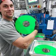 Zaměstnanec ukazuje vinyly.