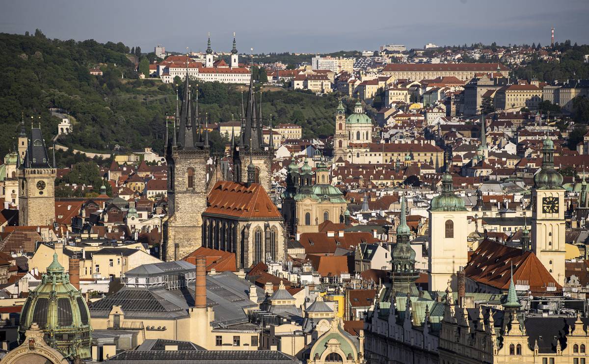 Stověžatá Praha, snímku dominuje Týnský chrám, v pozadí u petřínských sadů bíle září Strahovský klášter.