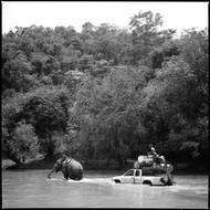 Vesničané překonávají za pomoci slona rozvodněný potok. Vojenské úřady přerušily dodávky potravin, léků a paliva, což vesničany přinutilo používat k přepravě zboží cesty džunglí. 18. července 2023.