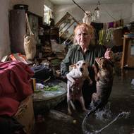 Na snímku žena Tetiana drží své mazlíčky Tsatsu a Chunyu ve svém domě, do kterého vtéká voda z Kachovské přehrady, v Chersonu, 6. června.