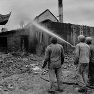 Během několika minut shodili dělníci bagrem střechu domu v Příčné ulici i s Petrem Vozákem na střeše, 5. května 1993. 