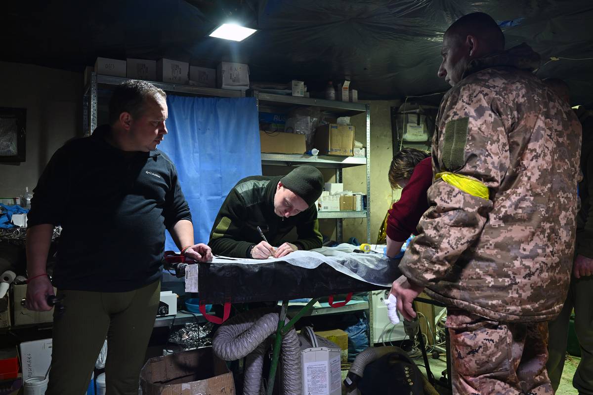Saša (zcela vlevo), čtyřicetiletý ukrajinský chirurg, řídí činnost vojenské polní ošetřovny nedaleko Avdijivky na Donbase. 