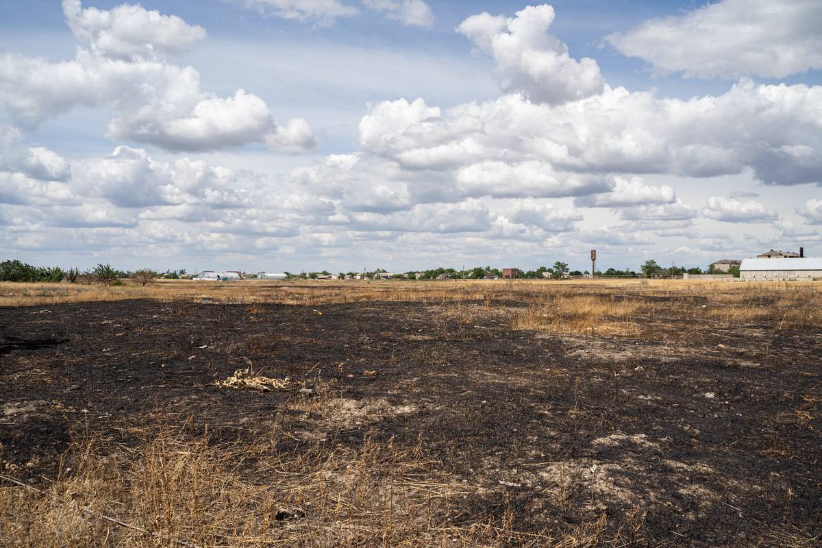 Během natáčení reportáže jen pár desítek metrů od reportérů dopadla dělostřelecká munice ráže 152 milimetrů. Na snímku spálená krajina v obci Posad Pokrovske.