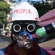 Demonstrant s improvizovanou ochranou proti slznému plynu a s podomácku vyrobeným ochranným štítem, snímek z 2. března 2021.