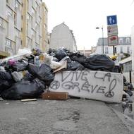 Snímek ulice zabarikádované odpadky v Paříži, 20. března. Několik málo sběrných vozů obnovilo o víkendu svoji činnost, většina však stále zůstává ve stávce.