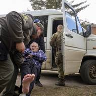 V neděli ale šéf ukrajinské armády Oleksandr Syrskyj připustil, že situace není jednoduchá. (Policisté a dobrovolníci nakládají staršího muže do dodávky ve vesnici Buhajivka, 11. května.)