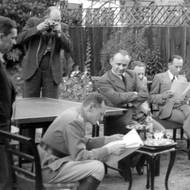 Českoslovenští zpravodajci se v britské emigraci dozvídají o Heydrichově teroru v Čechách a na Moravě. Jejich šéf František Moravec, ideový tvůrce operace Anthropoid, uprostřed se založenýma rukama. 