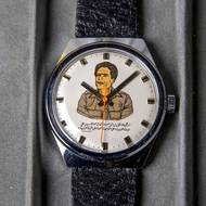 Tyhle hodinky byly vyrobeny pro libyjského vůdce Muammara Kaddáfího, který v roce 1978 navštívil ČSSR. Československo do Libye dodávalo mimo jiné i semtex, o němž se spekulovalo v souvislosti s útokem na letadlo spolenčnosti PanAm, které se zřítilo nad Lockerbie.