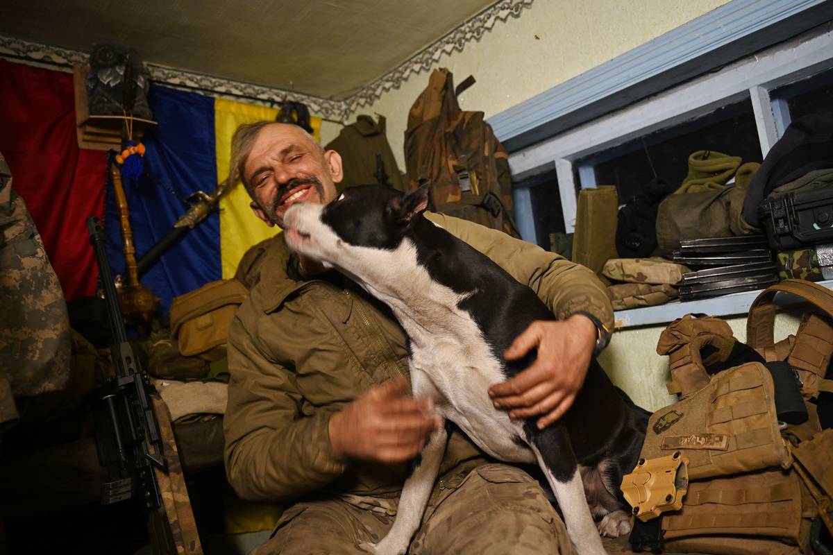 Ukrajinský snajpr Ivanovič ve své komůrce na základně nedaleko Avdijivky. Na klíně má svého psa Barika. Za těch deset let, co působí v aktivních bojových jednotkách, se jako člověk prý úplně změnil.