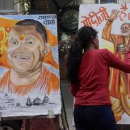 Studenti malují před slavnostním dnem výzdobu v ulicích Ajódhjy. Portrét premiéra Módího a premiéra státu Uttarpradéš Yogiho Adityanatha, který je zároveň hinduistickým mnichem. 