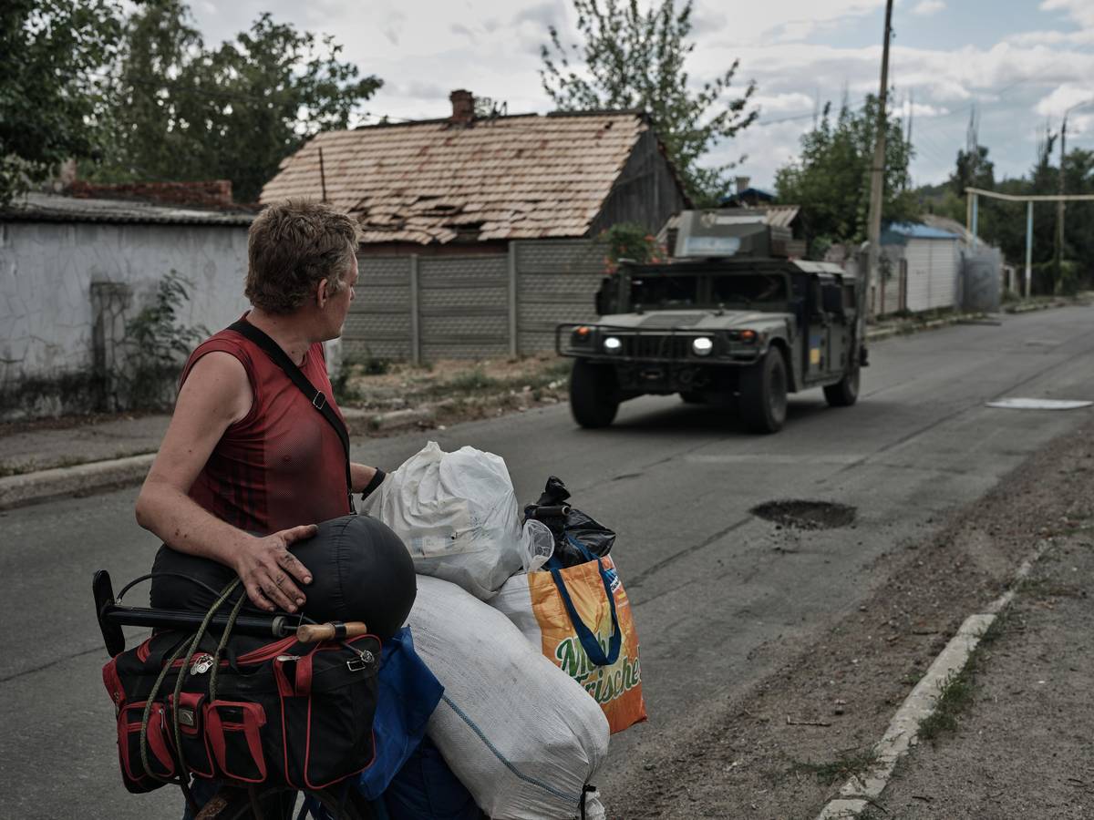 Budovy v plamenech, opuštěné ulice poseté troskami. Kdysi poklidné hornické město Toreck na východě Ukrajiny se proměnilo v peklo plné ruin a popela. I když bylo v prvních týdnech války těžce zasaženo, jeho obrana se nikdy nezlomila. (Ukrajinští vojáci během hlídkování ve městě, 30. července.)