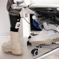 Zatímco vypráví svůj příběh, napájí si Ruslana u pracovního stolu svou umělou končetinu. Na klíně jí odpočívá její pes, který ji všude provází.