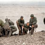 Den D: Vojáci vytahují vyčerpané kamarády z vody. 
Pláž Omaha (Normandie), 6. června 1944.

