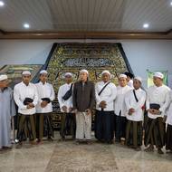 Turisté pózují v muzeu pro společnou fotografii před černou hedvábnou tkaninou, která je zdobena zlatou a stříbrnou výšivkou s verši z koránu. Říká se jí kiswah a slouží k zakrytí Ka’aby - svatyně v mešitě Al-Haram v Mekce, která je považována za nejposvátnější místo islámu.
