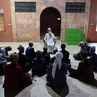 Imám káže v rozestavěné mešitě, která má zatím střechu z vlnitého plechu, ale jednou by to měla být velkolepá stavba, která má pojmout až sto tisíc věřících.