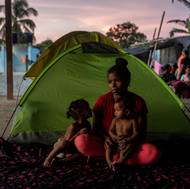 Migranti pocházejí z různých zemí: Afghánci utíkají před vládou Tálibánu, Venezuelané hledají útočiště před ekonomickým kolapsem, Číňané prchají před autoritářstvím a mnozí další jsou hnáni vidinou lepšího života. 

(Yineska Andreina Colina (18) sedí se svými dvěma dcerami, Enyerlis Sofií Colinou (2) a Eduanyerlis Saray Colinou (9 měsíců). Než se dostaly do Capurgany, Yinesce došly peníze a neměla tušení, jak převaděčům zaplatí za cestu přes džungli. Capurganá, Kolumbie, 30. července 2023.)