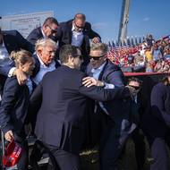 Kategorie Jednotlivá fotografie: Jabin Botsford pro The Washington Post. Červencový pokus o atentát na Donalda Trumpa a následná medializace jsou zlomovým okamžikem loňské prezidentské kampaně, který ovlivnil nejen nadcházející volby ve Spojených státech, ale i politickou budoucnost země. Krátce po střelbě republikánský kandidát na prezidenta v roce 2024 vykřikl „Bojujte, bojujte, bojujte!“, z čehož se pak stal jeden ze sloganů jeho příznivců.

(Ochranka pomáhá Donaldu Trumpovi odejít z pódia chvíli poté, co byl během předvolebního mítinku postřelen do ucha. Vyfoceno 13. července 2024 ve městě Butler v Pensylvánii.)