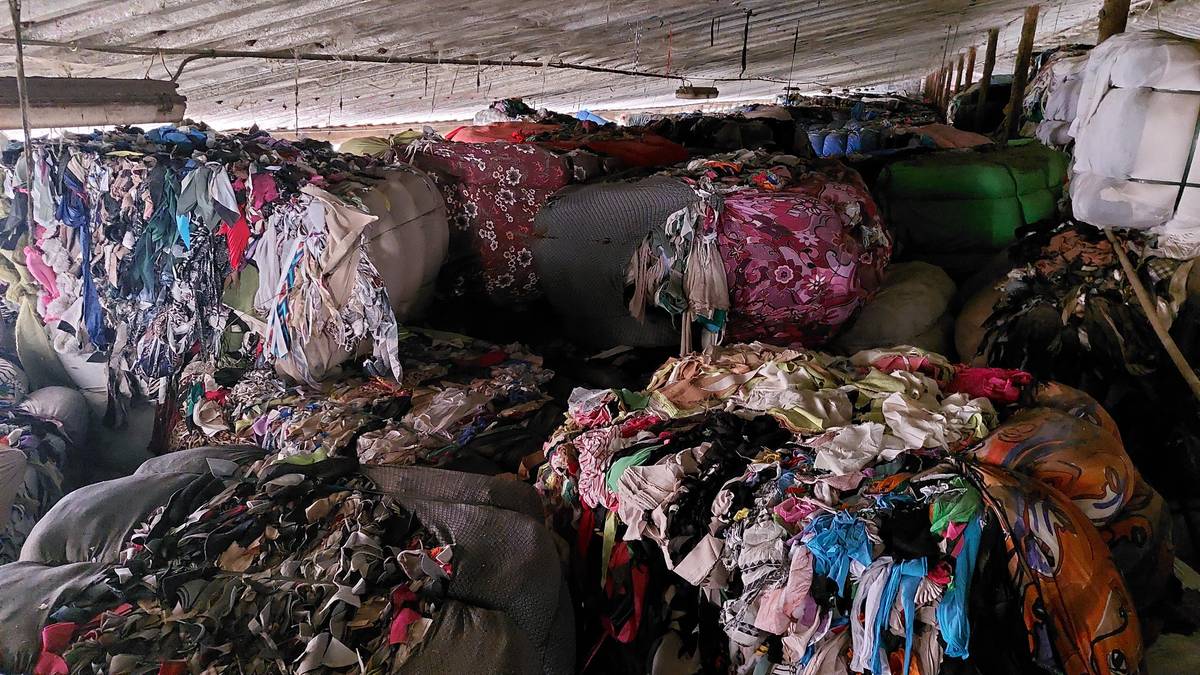 Haly v bývalém JZD jsou po okraj naplněné textilním odpadem z Itálie.