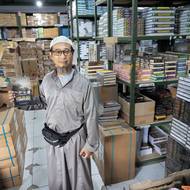 Jednapadesátiletý učitel angličtiny Dadang Budiana ukazuje ve školním skladu učebnic knihu, kterou sepsal o historii Tembora a místní internátní školy Al-Fatah.