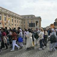 Na Svatopetrské náměstí ve Vatikánu ihned začali přicházet truchlící. Na snímku nese skupina lidí dřevěný kříž.