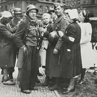 Vojáci samostatného průzkumného oddílu na Albrechtově (Štefanikově) náměstí před Smíchovskými (Štefanikovými) kasárnami, vítáni sestrami z nemocnice vládního vojska, Praha-Smíchov 6. května 1945.