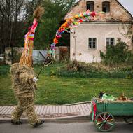 Oblek Jidáše dále doplňuje vysoká čepice z rákosu a zdobený trnový prut v ruce.