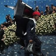 Americký rapper a zpěvák André 3000 dorazil na galavečer s dětským klavírem připevněným na zádech. Klavír je model ve tříčtvrteční velikosti vyrobený designovým studiem Pink Sparrow.