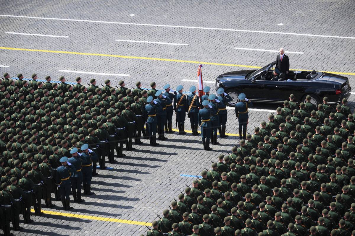 Přehlídku odstartoval ruský ministr obrany Andrej Bělousov. Na snímku vestoje z jedoucího otevřeného vozu zdraví vojáky, kteří zaplnili velkou část Rudého náměstí.