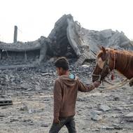 Palestinský chlapec u budovy zničené izraelskými údery v uprchlickém táboře Bureij v centrální části Pásma Gazy. (10. července)
