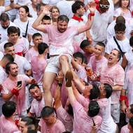 Běžci, z nichž je většina oděna v tradičně bílých kalhotách a košili s červeným šátkem kolem krku, běží před šesti býky a několika doprovodnými voly. 