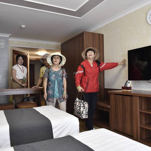 První turisté oblasti Wonsan Kalma si 1. července prohlížejí nový hotelový pokoj.