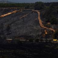 Hasičské auto projíždí kolem území spáleného lesním požárem nedaleko města Congosta ve Španělsku, 11. srpna.