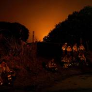 Hasiči si dávají pauzu během hašení lesního požáru, který se blíží k okolí Villanueva de la Sierra ve Španělsku, 15. srpna.