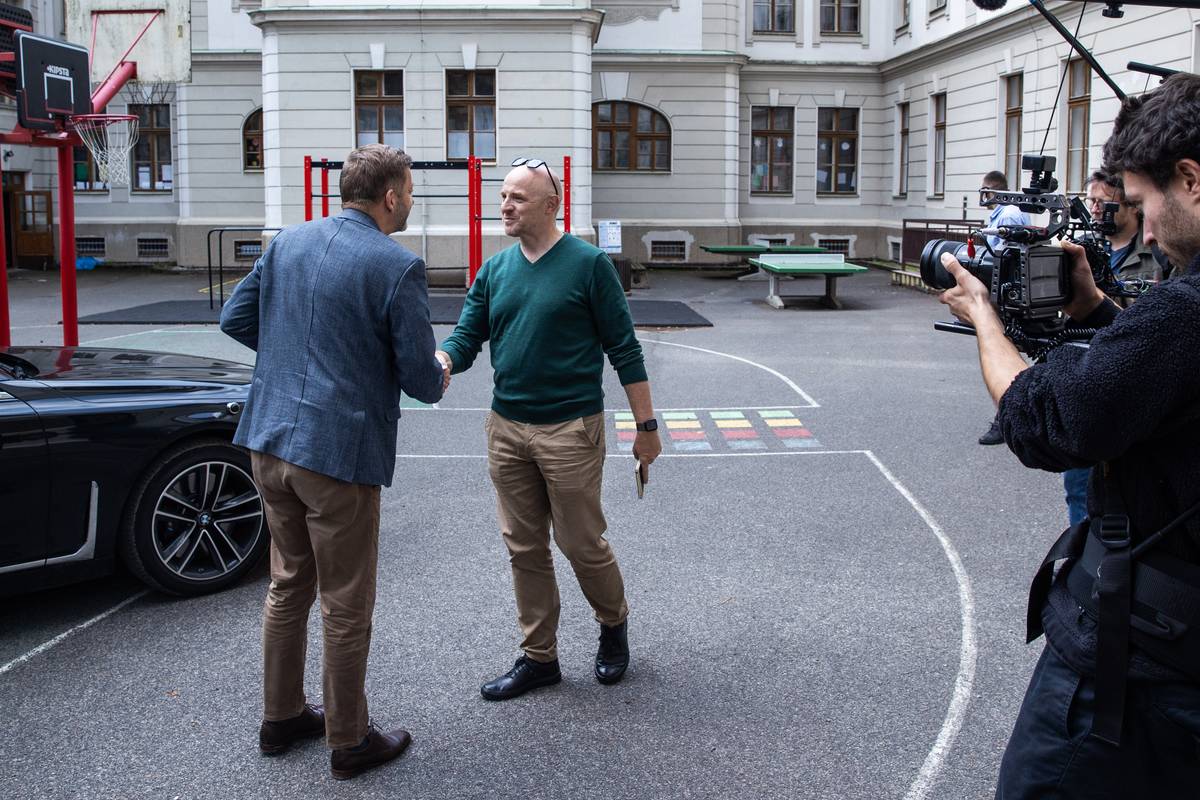 Bývalý učitel na školním dvoře. Reportér Jiří Kubík se zdraví s ministrem vnitra a předsedou STAN Vítem Rakušanem, bývalým středoškolským učitelem, na dvoře příbramské základní škole Jiráskovy sady.