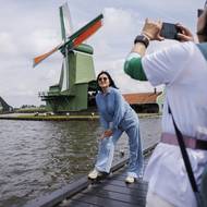 Jde o jedny z nejmalebnějších pohledů Nizozemska, navíc jsou snadno dostupné z Amsterdamu. Vesnice Zaanse Schans a její větrné mlýny letos přilákají odhadem 2,8 milionu návštěvníků. (Turisté se fotí před větrnými mlýny v Zaanse Schans, 31. července 2025.)