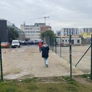 Zkratka vede přes parkoviště a „díru v plotě“.