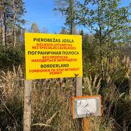 Cedule uprostřed lesů varuje, že se lidé nesmí k ruské hranici přiblížit.