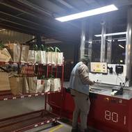 Pracovník vyrovnává tašky na regál, odkud si je převezme kurýr.