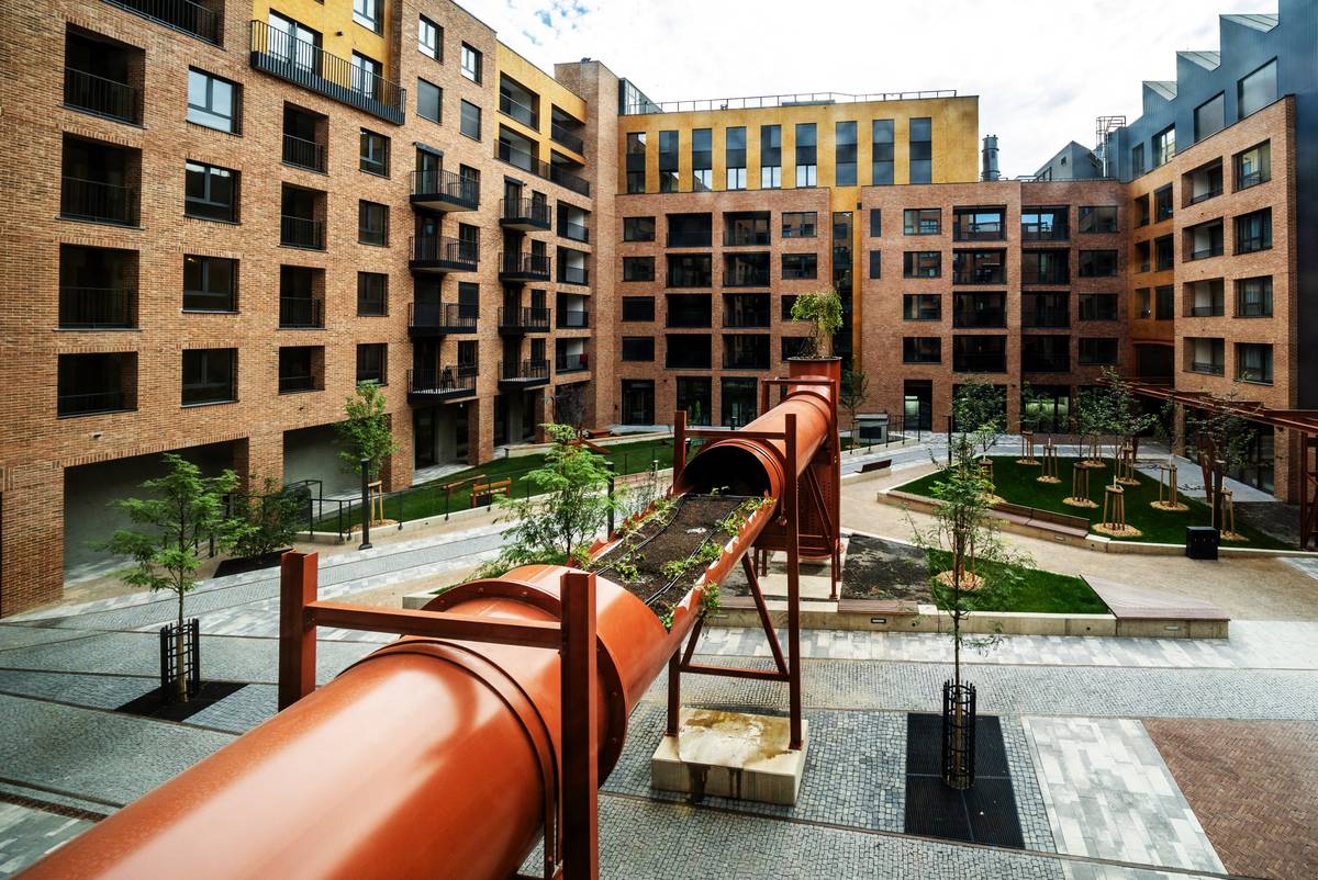 Nová rezidenční čtvrť Lihovar na pražském Smíchově se už z dálky hlásí ikonickými továrními komíny, pilovou střechou a fasádami z červených cihel. Bude pokračovat další etapa projektu. Celý projekt obsáhne více než pět set bytů.