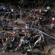 Žena sedí na padlém sloupu uprostřed škod způsobených tajfunem Kalmaegi v Talisay. (Filipíny, 5. listopadu)