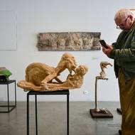 Návštěvník výstavy si prohlíží sochu nazvanou Samaritán.