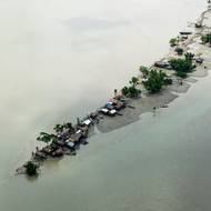 Podle závěrů vládních vědců pohlcuje stoupající hladina moří (způsobená klimatickými změnami) nízko položené oblasti. A stále silnější bouře tlačí slanou vodu hlouběji do vnitrozemí, kde se studny a jezera stávají brakickými. (Osada rybářské komunity, která byla kvůli změně klimatu vysídlena do Jhulonto Para,  13. července.)