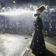 Policisté namířili slzný plyn proti demonstrantovi oblečenému v oděvu derviše během protestu v den, kdy byl starosta Istanbulu Ekrem Imamoglu uvězněn. (Istanbul, 23. března)
