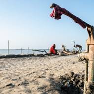 Na pobřeží Bangladéše, kde se mohutné himálajské řeky setkávají s mořem, určuje voda rytmus života. A také každý zápas. (Rybář zatlouká mrtvý strom vedle nefunkční ruční pumpy na břehu řeky Kholpetua v okrese Khulna, vyfoceno 20. října.)