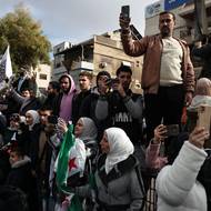 Sýrie si v pondělí připomněla první výročí svržení Bašára Asada a jeho autoritářské vlády. Země, zmítaná válkou, se i nadále snaží zotavit a najít politickou stabilitu po letech konfliktu. Na snímku obyvatelé hlavního města Damašku čekají na vojenskou přehlídku.