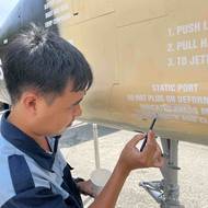 Obnova původních nápisů na americké helikoptéře v Muzeu válečných pozůstatků.