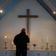 „Od dětství jsem zvyklý na myšlenku, že půdu lze pouze pronajímat. Vždy jsme byli zvyklí na myšlenku, že naši půdu vlastníme kolektivně,“ pokračuje Kaaleeraq Ringsted, bývalý rybář a lovec, který se v Kapisillitu narodil.
(Čtyřiasedmdesátiletý Kaaleeraq Ringsted zapaluje svíčky v kostele v Kapisillitu, 20. ledna.)